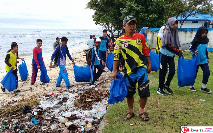 Secara gotong royong anggota Pos TNI AL dan para siswa melakukan giat bersih pantai