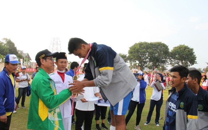 Asisten III Gotri Suyanto memberikan medali emas cabor Sepakbola kepada Kapten tim Kota Bengkulu.