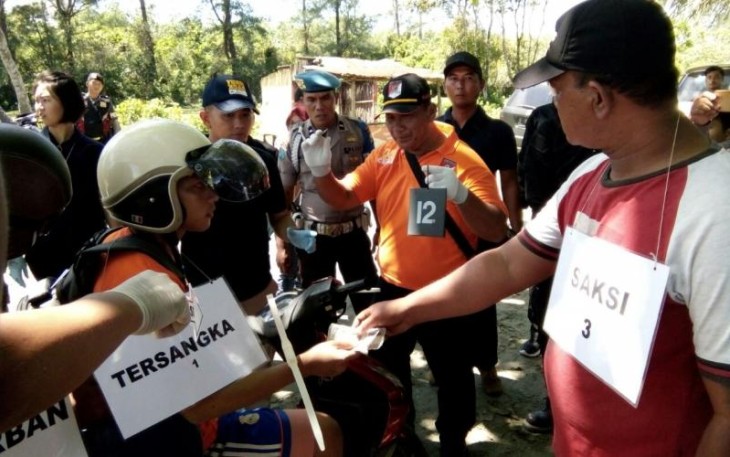 DM saat melakukan adegan rekonstruksi pembunuhan terhadap korban di TKP 