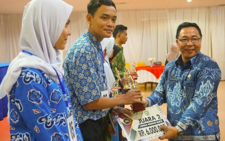 Kepala Dinas Perpustakaan dan Kearsipan, Atisar Sulaiman Memberikan Hadiah Kepada Pemenang Lomba 