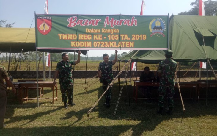 Personil TNI Sedang Memasang Spanduk Bazar Murah 