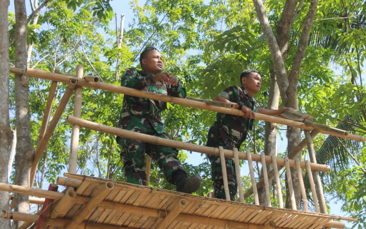 Dua Satgas TMMD Berdiri Diatas Gasebo di Atas Kolam