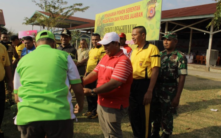 Muspika Kecamatan Samalanga Kabupaten Bireuen Mulyadi S H Diikuti Kapolsek AKP Bahrun Bersama DanRamil 02 Kapten Infantri M Gade terlihat Menyatu Erat Ketika Wakil Bupati Dr H Muzakkar A Gani S H  M. Si (Membelakangi Lensa) Menyerahkan Bibit Pohon Secara Simbolis Untuk Dibawa dan Ditanam di Lahan Kawasan Tugas Mereka. Penyerahan Tersebut Berlangsung Seusai Mengawali Melakukan Penanaman Bagian Dari Total Bibitnya Sebanyak 2020 Pohon di Komplek Gedung SKB