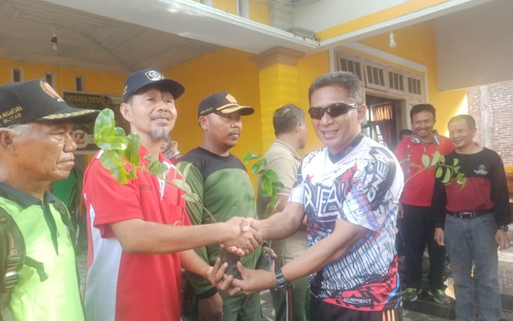 Wakil Bupati Blitar Marhaenis Urip Widodo (kanan) saat menyerahkan bibit tanaman pohon kepada warga