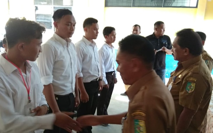 Bupati Batu Bara Ir Zahir M.AP diwakili Asisten I Rusian Heri didampingi oleh Kadisnaker Erinaldo saat memberikan buku panduan.