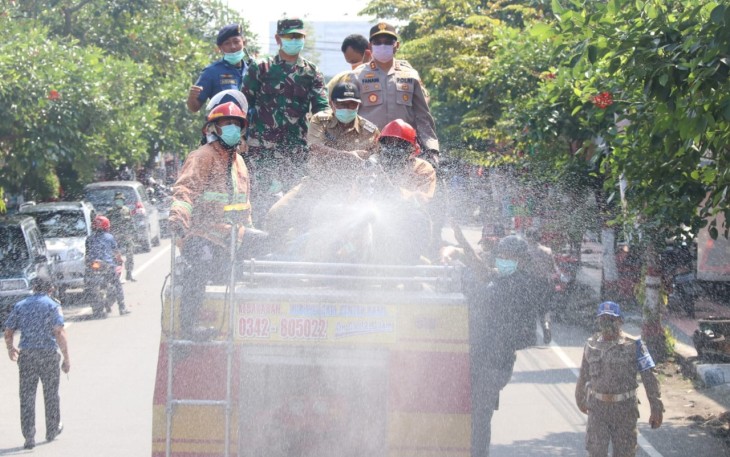 Dandim 0808/Blitar Letkol Inf Kris Bianto (dua dari kiri berdiri) saat menyemprotkan Disinfektan diatas Truk Damkar 