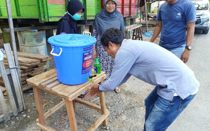 Ketua DPD PAN SBB Rauf Latulumamina sedang praktikan cara cuci tangan yang benar kepada masyarakat dusun Pelita Jaya.