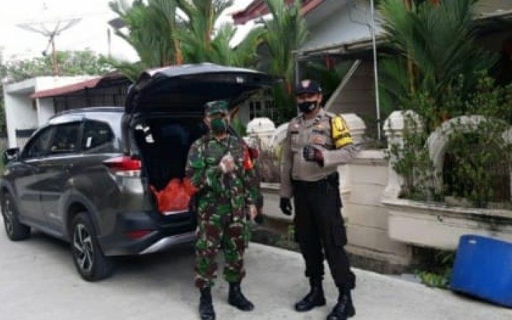 Babinsa 08 Batu Selicin Serka Dadang Hendarsah dan Bhabinkamtibmas Kelurahan Batu Selicin Polsek Lubuk Baja Aipda Doni Admiral saat mempersiapkan sembako yang akan dibagikan kepada masyarakat