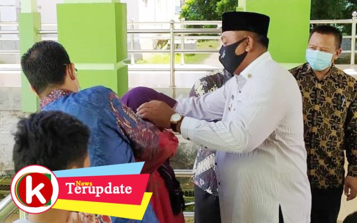Bupati Aceh Singkil Dulmusrid saat membagikan masker kepada para pengunjung Rumah Sakit setempat.