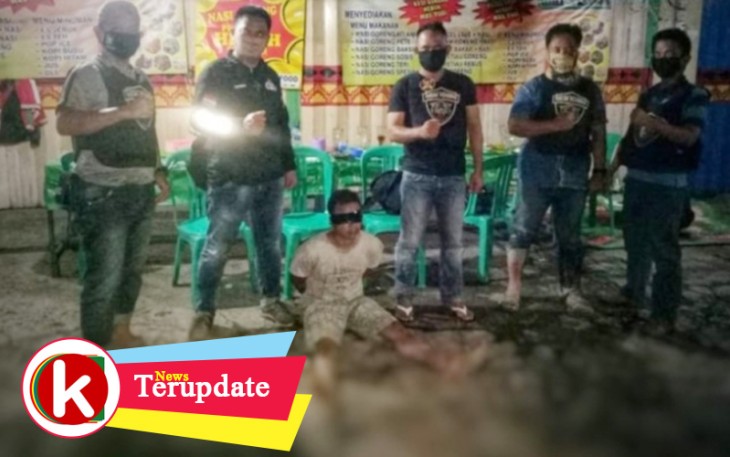 Tersangka (tengah) setelah berhasil ditangkap