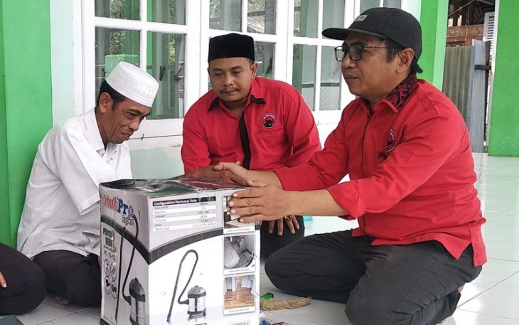 Anggota DPRK Aceh Singkil Taufik didampingi pengurus Partai PDI Perjuangan menyerahkan bantuan alat pembersih debu (vacuum cleaner).