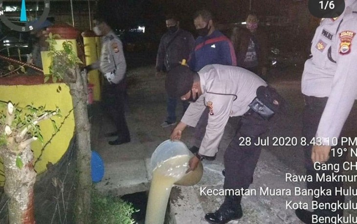Petugas saat membuang tuak hasil sitaan dalam patroli