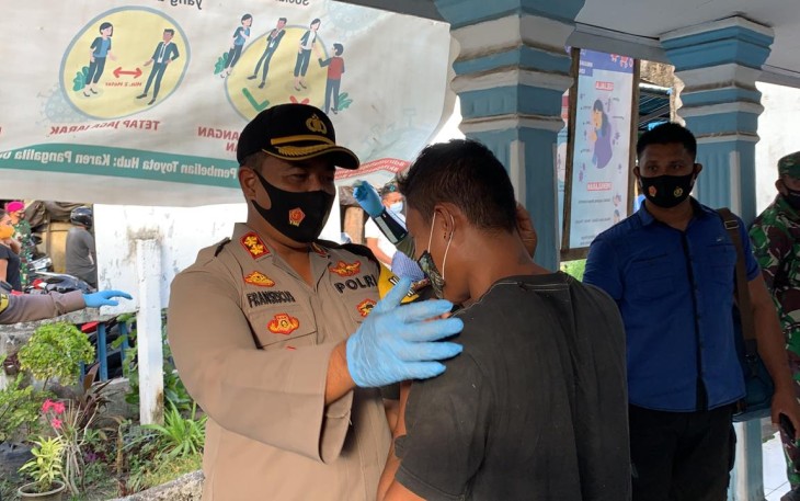 Kapolres Bitung saat memakaikan masker kepada salah satu warga yang terjaring Operasi Yustisi