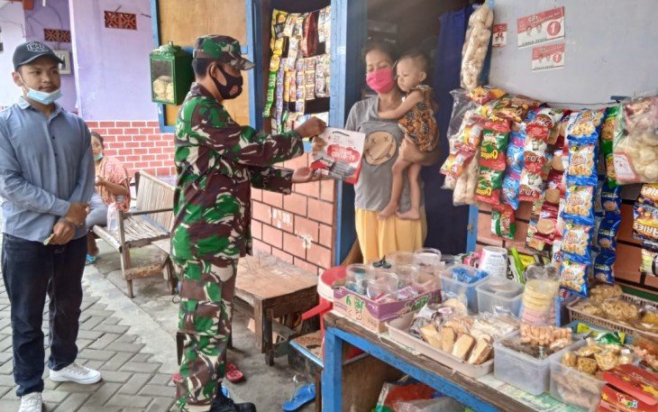 Babinsa Kelurahan Sewu Koramil 04/Jebres Kodim 0735/Surakarta Serka Suryanto.membagi-bagikan masker dan sabun kepada warga di RW 8 wilayah Kelurahan Sewu, Sabtu, (23/1/2021).