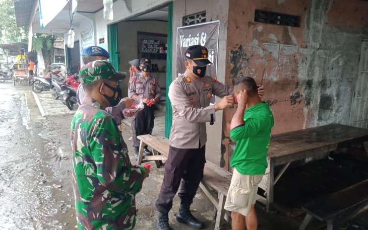 Kapolsek Brangsong AKP Amin Supangat SH MM.,memakaikan masker kepada masyarakat yang tidak taat prokes