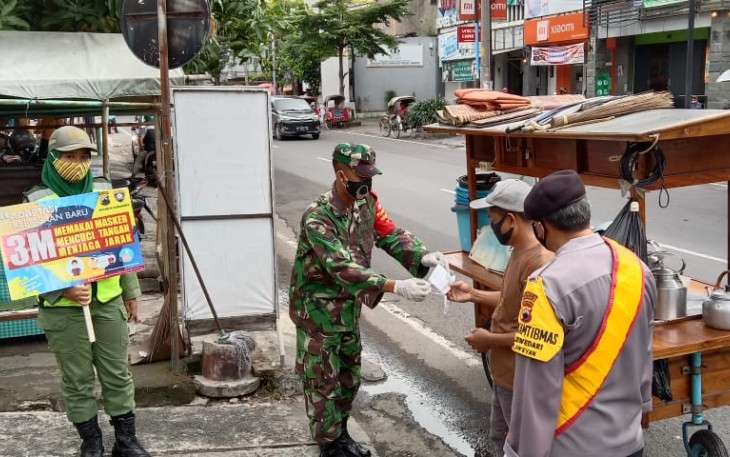 Babinsa Kelurahan Sriwedari Koramil 01/ Laweyan Kodim 0735/Surakarta Sertu Widodo dan Kopka Subiyanto, bersama Bhabinkabtibmas Aiptu Tatang membagikan masker kepada masyarakat