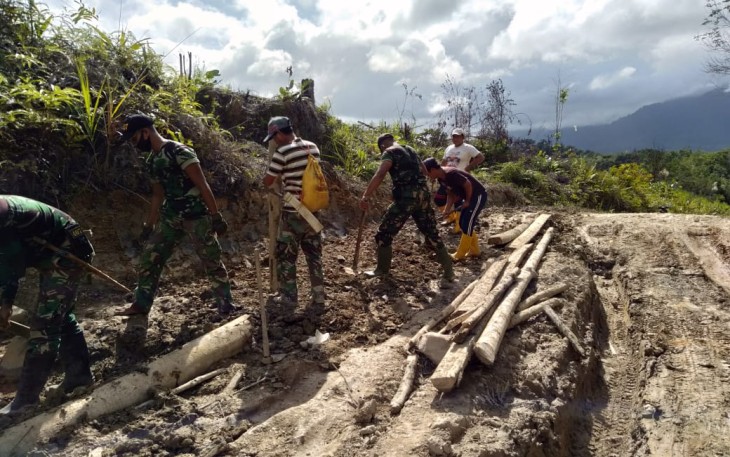 Yonif 407/PK bersama masyarakat melaksanakan gotong-royong perbaikan jalan yang dilalui warga di Desa Nanga Bayan, Kecamatan Ketungau Hulu, Kabupaten Sintang, Kalbar.