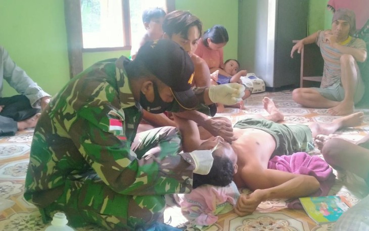 Satgas Pamtas RI-Malaysia Yonif 407/PK Pos Muakan mengobati Jeli Ridwan (27) warga Desa Muakan Petinggi, Kec. Ketungau Hulu Kab. Sintang yang mengalami musibah terkena dahan pohon saat memotong kayu.