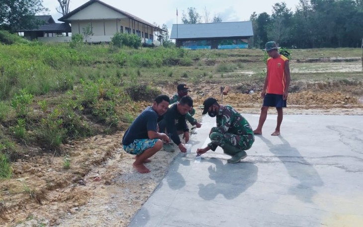 Prajurit TNI Satgas Pamtas RI-Malaysia Yonif 407/PK bersama masyarakat dengan gotong royong melaksanakan karya bhakti pengecatan lapangan voly di Desa Sungai Kelik, Kec. Ketungau Hulu, Kab. Sintang, Kalimantan Barat. Jum'at (26/03/21).