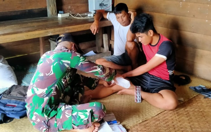 Prajurit TNI Satgas Pamtas RI-MLY Yonif 407/PK Pos Muakan memberikan pertolongan dan pengobatan kepada warga yang terluka di Desa Muakan Petinggi, Kecamatan Ketungau Hulu, Kabupaten Sintang, Kalimantan Barat. Senin (12/04/21)