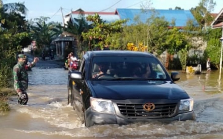 Sejumlah Desa di Gunung Mas Terendam Banjir, Babinsa Pandu Warga Sebrangi Jalan
