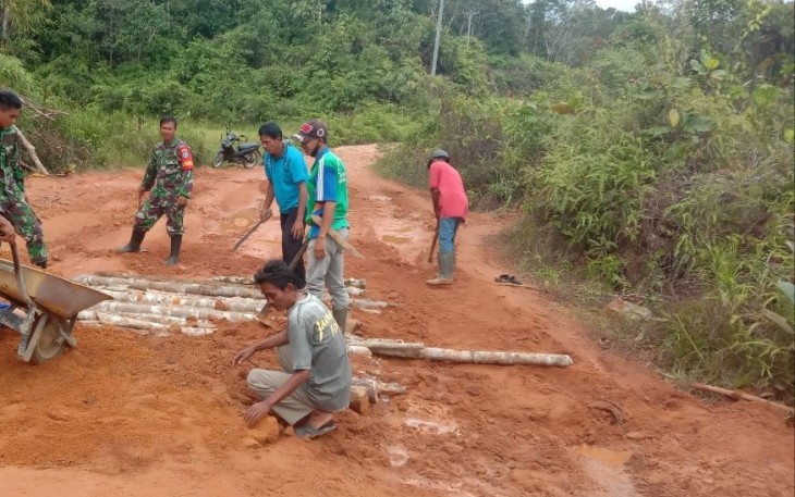 Babinsa 07/Mempawah Hulu Bersama Masyarakat Karya Bakti Perbaiki Jalan Berlubang