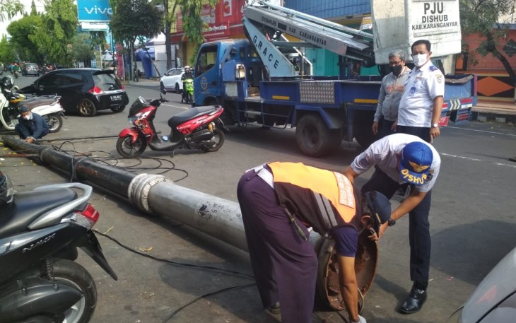 Sejumlah Petugas Sedang Melakukan Evakuasi Tiang lampu Penerangan Jalan yang Roboh Usai Menimpa Empat Sepeda Motor di Kawasan Jalan Lawu No10 Karanganyar