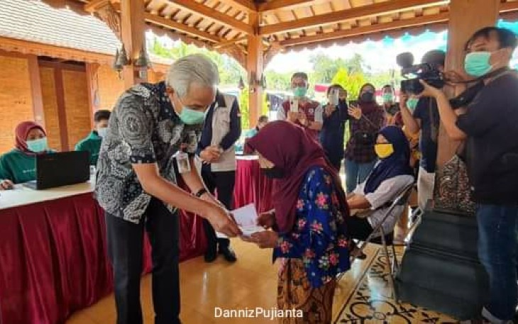 lGubernur Jawa Tengah Ganjar Pranowo saat memeriksa kartu salah satu peserta vaksin di Magelang