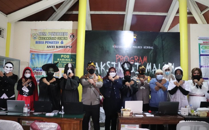 Kapolres foto bersama dengan petugas Vaksin yang berkostum hantu di Balaidesa Poncorejo Sabtu 25/9/2021