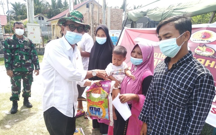 Camat Singkil Sofian, saat menyerahkan beras kepada warga peserta vaksin, dalam kegiatan vaksinasi covid-19 buang dilaksanakan disalah satu desa Kecamatan setempat.