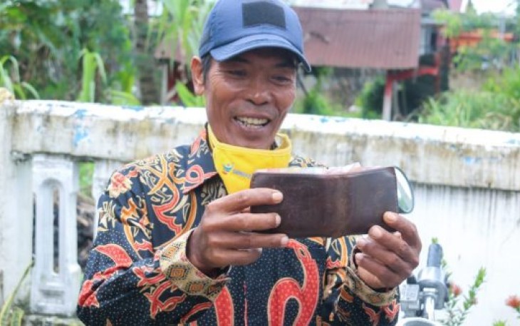 Salah Satu Warga Diberikan Dompet Milik Helmi Hasan Dan Seiisinya 