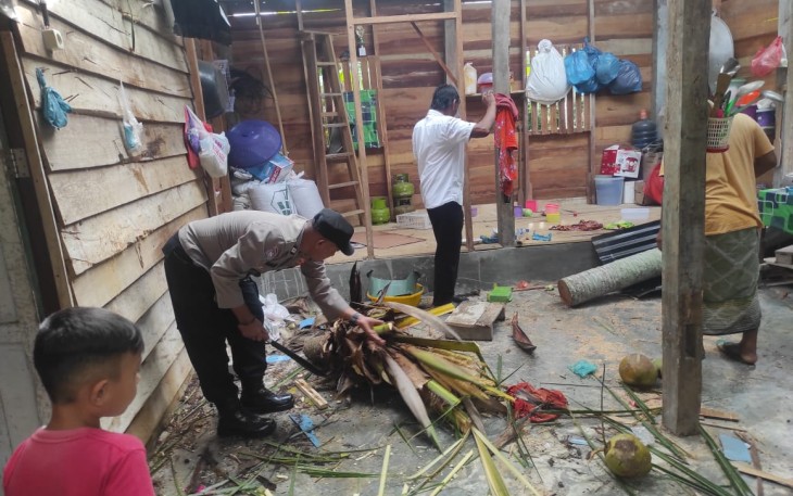 Anggota Polsek Peureulak Barat saat Bantu Warga yang Rumahnya Tertimpa Pohon