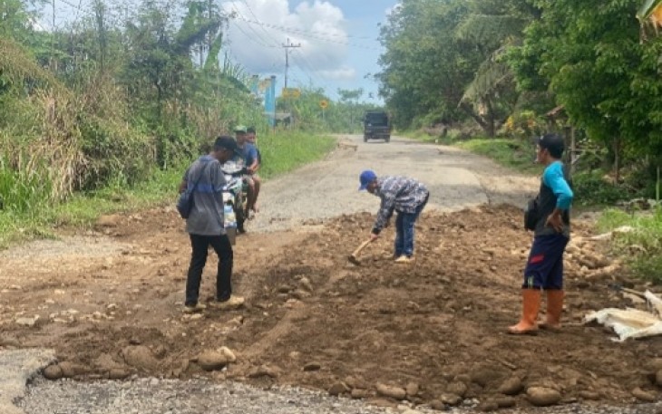 Warga gotong royong timbun jalan berlubang