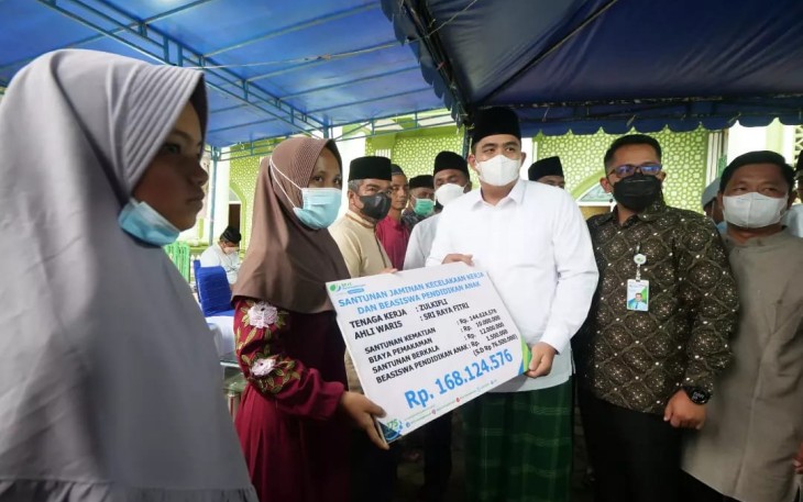 Plt Bupati Bintan, Roby Kurniawan saat menyerahkan bantuan santunan jaminan kecelakaan kerja dan beasiswa anak dari BPJS Ketenagakerjaan sebesar Rp.168.124.576 kepada Ahli waris Sri Raya Fitri. (2000 pixel).