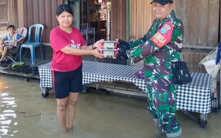 Babinsa saat turut salurkan Makanan Kepada Warga Terdampak Banjir 