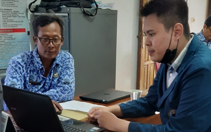 Mahasiswa bersama perangkat desa memasukan data hasil rekapitulasi