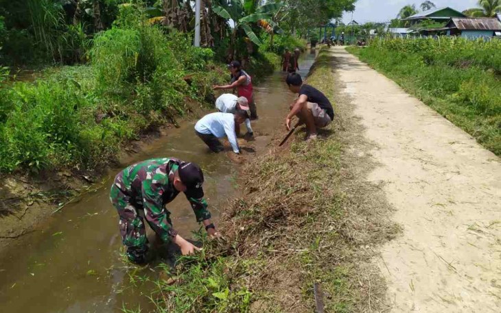 Satgas Pamtas Yonif Mekanis 643/Wns Bersama Warga Gotong Royong Bersihkan Saluran Irigasi
