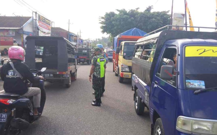 Sertu Rohmat siaga membantu warga Seberangkan jalan. Kamis (05/05/2022)