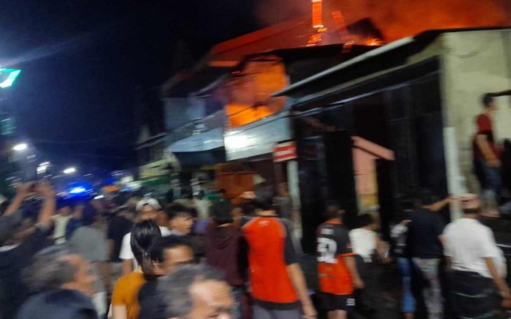 Warga bergotong royong berusaha memadamkan api rumah yang terbakar. Kamis (12/05/2022)