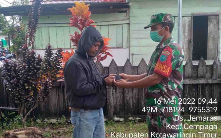 Sertu Marben bagikan masker ke warga yang melintas di jalan. Senin (16/05/2022)