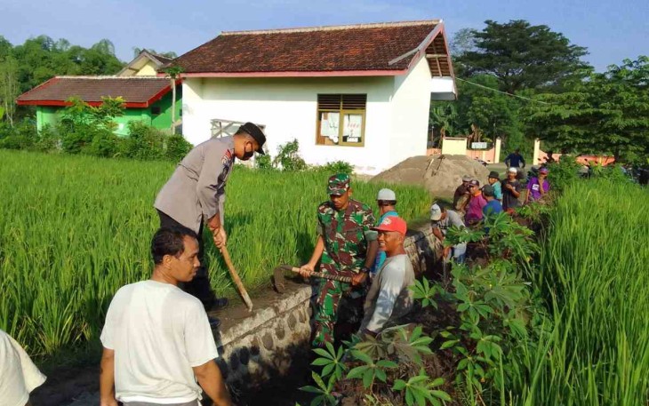 Sinergitas TNI-POLRI bersama warga bersihkan saluran irigasi 