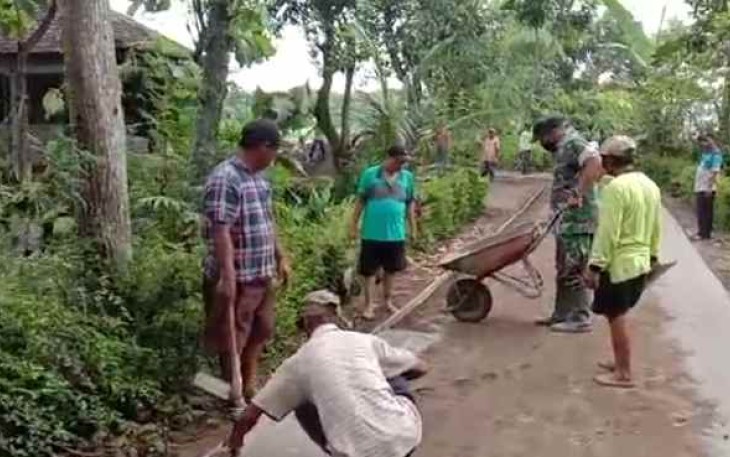 Sertu Edi berjibaku bersama warga pasang paving block