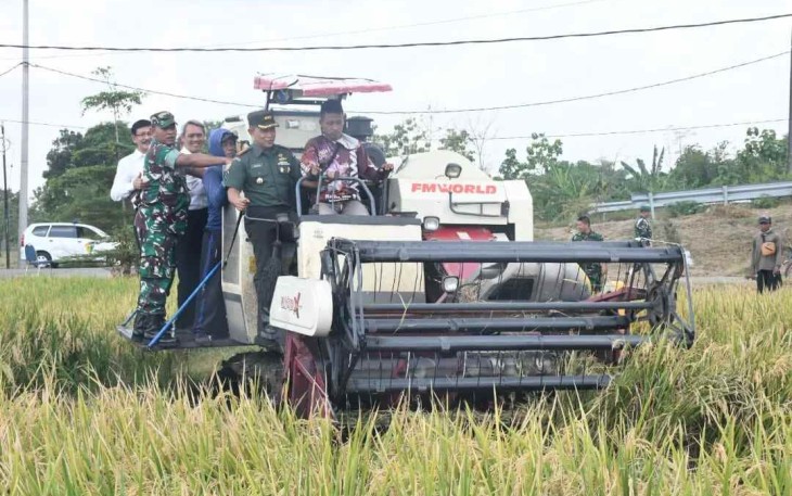 Danrem 081/DSJ saat menaiki traktor panen raya padi