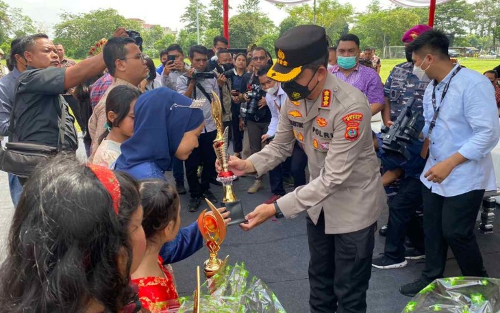 Kapolresta Medan saat memberikan bunga dalam peringati hari anak nasional di Medan