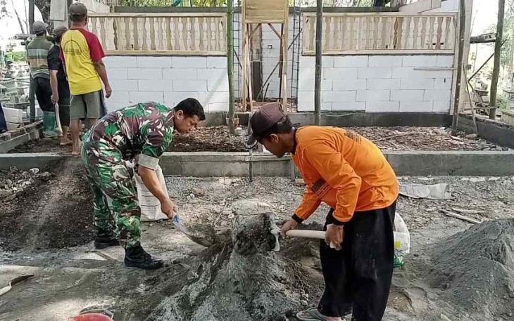 Serka Andik saat merehab makam bersama warga binaan. Minggu (2/10)