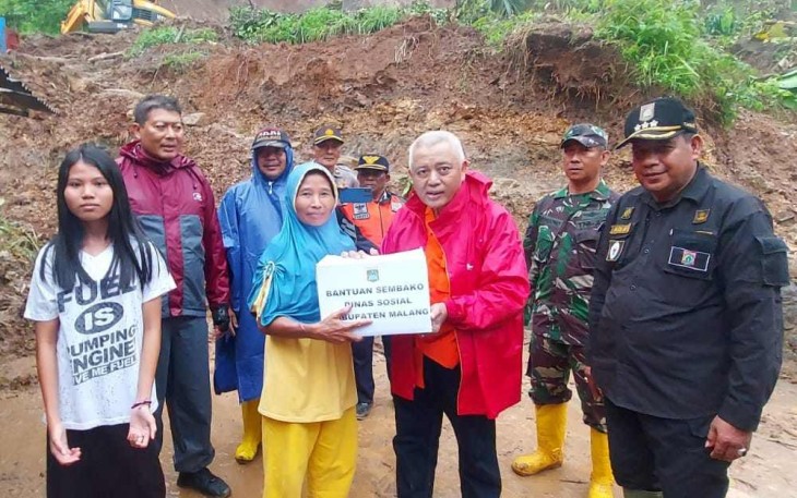 Bupati Malang, H. M Sanusi didamping Camat Dampit, Abai Saleh, saat menyerahkan bantuan pada korban longsor di Dampit, Jumat (21/10/2022).