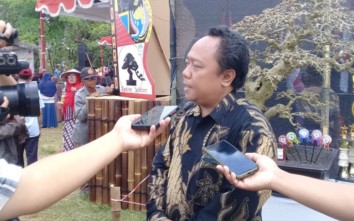 Kades Tirtomarto, Agung Nugroho saat memberikan keterangan pada Pameran dan Kontes Bonsai Lokal di lapangan desa setempat, Selasa (30/08/22)