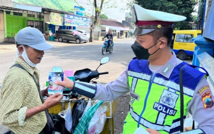 Anggota Unit Kamsel Satlantas Polres Karanganyar saat memberikan sosialisasi keselamatan lalu lintas kepada seorang pedagang keliling, Rabu (6/7/2022).