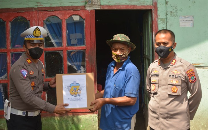 Kapolres Bitung bersama Kasat Lantas saat memberikan bantuan sembako kepada masyarakat kurang mampu
