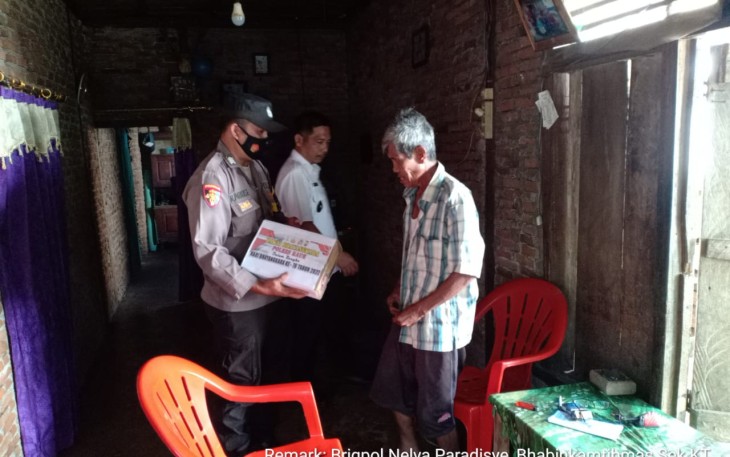 Bhabinkamtibmas saat Bagikan Bantuan Untuk Warga Kurang Mampu